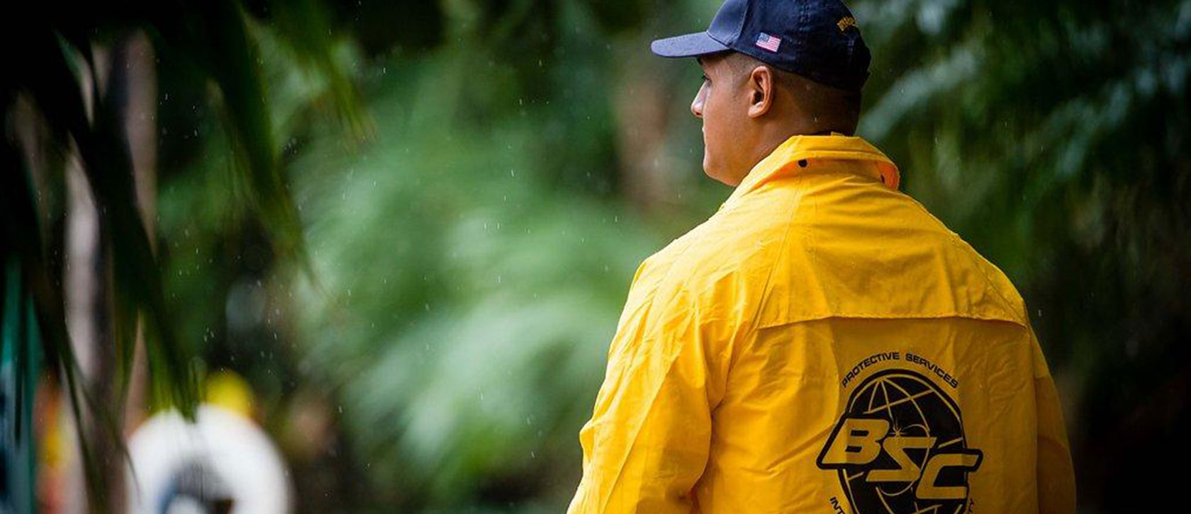 Bryant Security Company security guard wearing yellow raincoat outside in the rain
