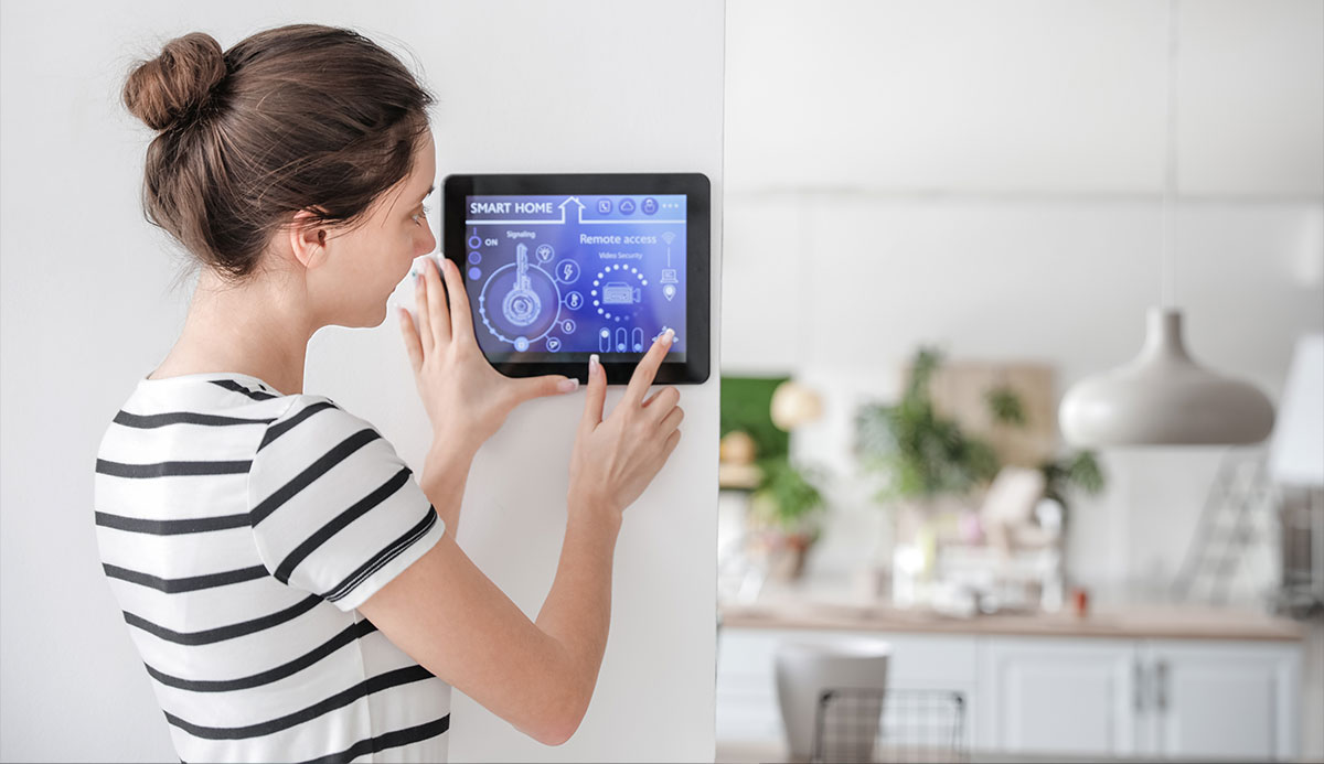 woman wearing a black and white striped shirt arming her smart home security alarm system